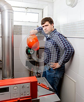 Confused plumber looking at complicated heating system