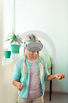 Confused schoolgirl trying to move in virtual reality.