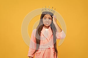 confused selfish teen girl in home terry bathrobe and princess crown, confusement