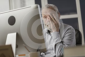 Confused senior citizen using a computer