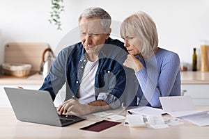 Confused senior husband and wife paying bills on Internet