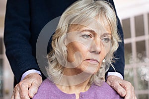 Confused Senior Woman Suffering With Depression And Dementia Being Comforted By Husband photo