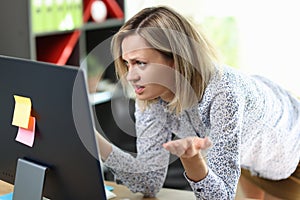 Confused and upset woman looking at computer screen