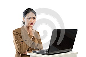 Confused woman in civil servant uniform looking at laptop