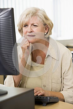 Confused woman frowning at computer