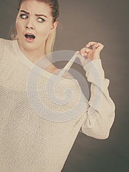 Confused woman holding her bra strap