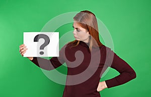 Confused woman holding question mark sign on background