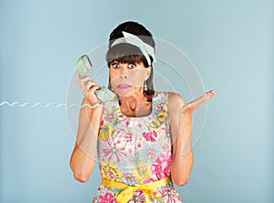 Confused woman holding telephone photo