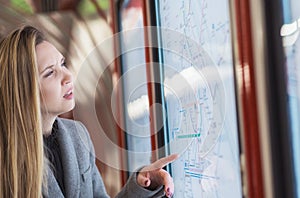 Confused woman looking to timetables in train station