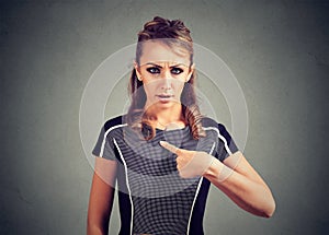 Confused woman pointing at herself with finger.