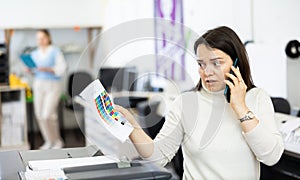 Confused woman printing office manager having telephone conversation