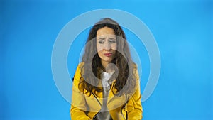 Confused woman saying no shaking head in denial over yellow background