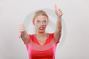 Confused woman showing thumbs up down gesture