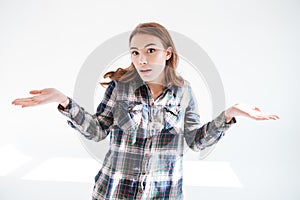 Confused woman shrugging shoulders and holding copyspace on both palms