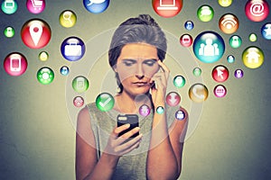 Confused woman using smartphone application icons flying out of cellphone