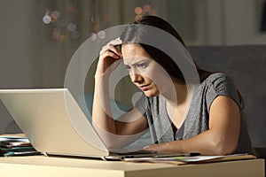 Confused woman working online late hours