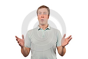 Confused young guy shrugged shoulders, guy in casual T-shirt spread arms isolated white background photo