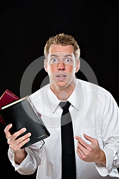 Confused young man holding bibles