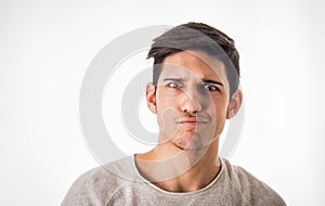 Confused young man looking at camera in studio