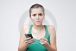 Confused young woman received bad news with sms.