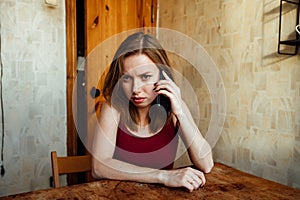 A confusing girl with a phone in her hands waiting for a call