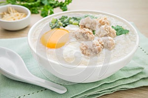 Congee with minced pork and boiled egg in bowl