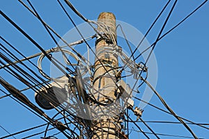 Conglomeration of electric cables, on a old power pole.