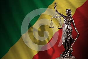 Congo flag with statue of lady justice and judicial scales in dark room. Concept of judgement and punishment