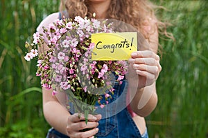 Congrats - beautiful woman with card and bouquet of pink flowers photo