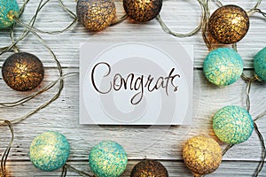 Congrats text on paper card with LED cotton balls top view on wooden background photo