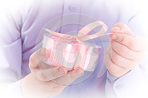 Congratulation! Boy open a gift in a pink box