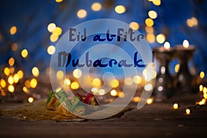 Congratulation: Eid al-Fitr Mubarak! Arabic sweets on a wooden s photo