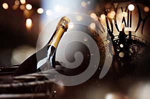 Congratulations with a bottle champagne and clock for new year