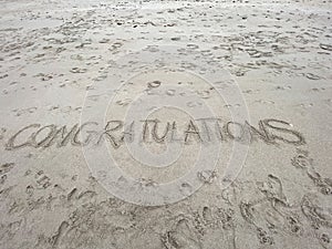 Congratulations written in the sand