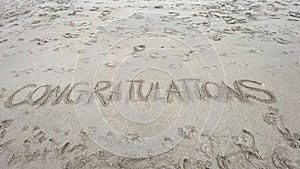 Congratulations written in the sand