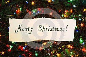 Congratulatory inscription merry Christmas on a Christmas garland on a dark background