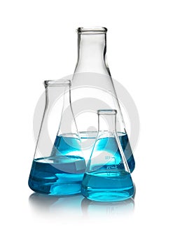 Conical flasks with liquid on table against white background