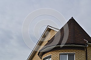 The conical roof of the house is brown