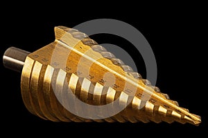 Conical step drill for drilling holes of different diameters, isolated on black background