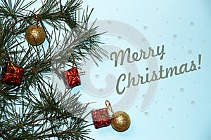 Coniferous branches, Christmas tree decorations, text Merry Christmas on a New Year`s blue background