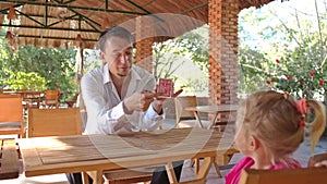 Conjurer Shows Card Pack Trick to Little Girl at Table