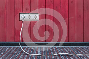 Connect the power and energy plug cable to the outlet on the red wooden wall surface