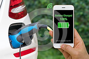 Connected Car Concept Illustrated by Smartphone App Showing Status of Battery Charged into Electric Vehicle
