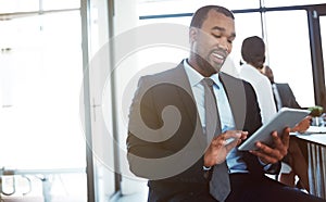 The connected exec is a current exec. a young businessman using a digital tablet during a meeting at work.