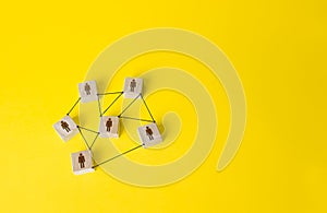 Connected people figures form a working team network. Cooperation and division of responsibilities among project participants