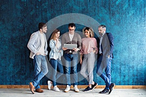 The connected team is an efficient team. Group of businesspeople using wireless technology together while standing in