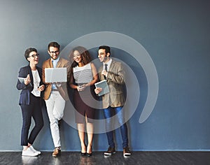 The connected team is an efficient team. Studio shot of a group of businesspeople using wireless technology together