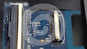 Connecting a flex cable to the laptop motherboard with tweezers, laptop repair in a service center