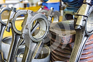 The connecting rod, piston and cylinder block in a disassembled condition in a car workshop