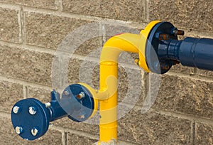 Connection of blue-and-yellow gas pipe, close-up from the street side